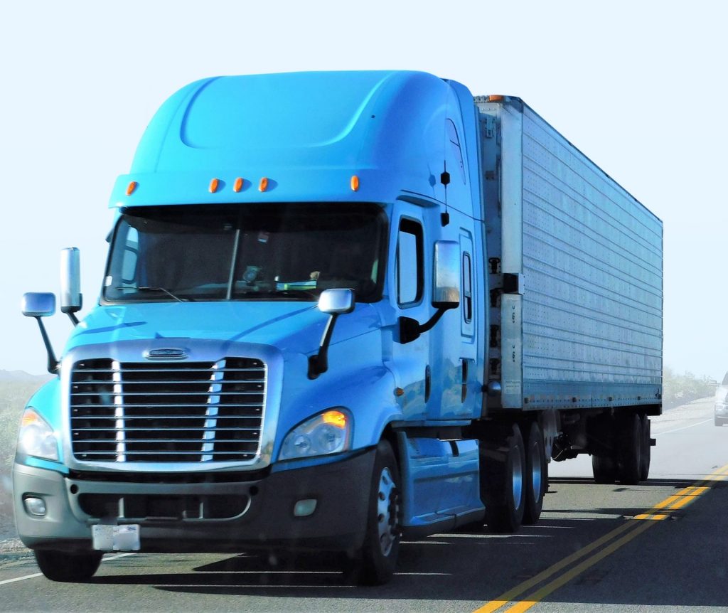 Blaues Frachtfahrzeug auf einer Landstraße – Moderner LKW für den Gütertransport.